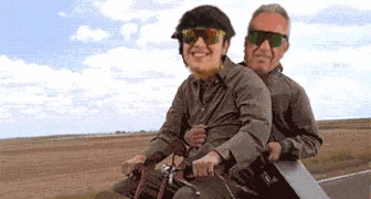 a man and a woman are riding a bicycle on a trailer .