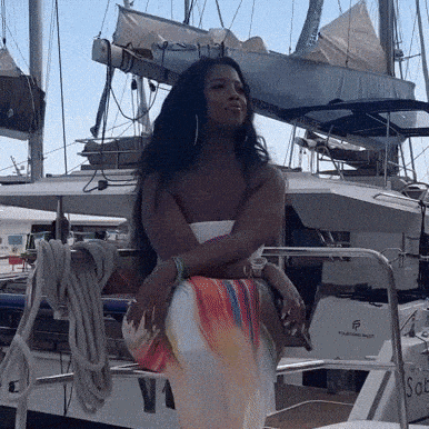 a woman is standing in front of a boat that says ' sol ' on it