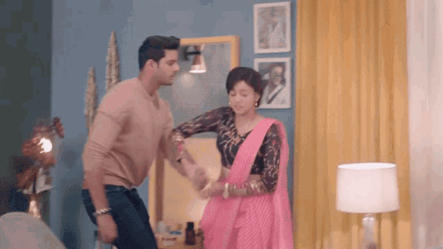 a man and woman are dancing together in a living room .