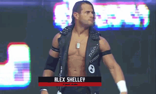 a wrestler named alex shelley is standing on the stage