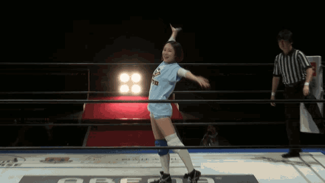 a woman in a blue shirt with pringles on it is standing in a wrestling ring