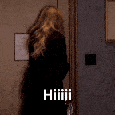 a woman standing in front of a door with the word hiiiiii written on it
