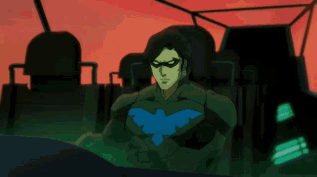 a cartoon character with a blue bird on his chest is sitting in a chair
