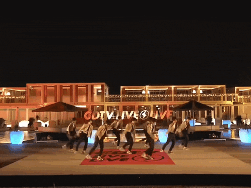a group of people are dancing in front of a sign that says cctv4 live live