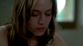 a close up of a woman 's face with her eyes closed in front of a window