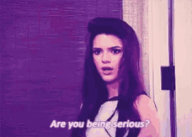 a woman is standing in front of a door and asking are you being serious