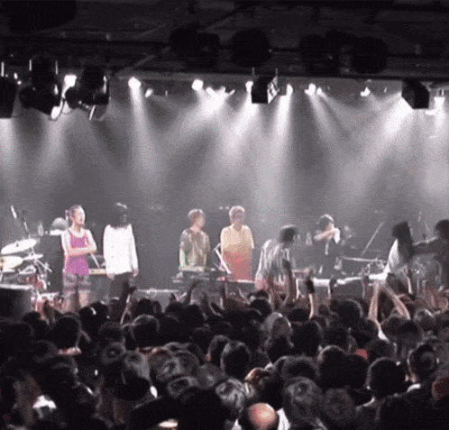 a group of people standing on a stage in front of a crowd of people
