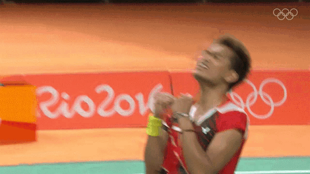 a man is standing in front of a rio 2016 sign