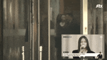 a tv screen shows a woman singing into a microphone and says jtbc on the bottom