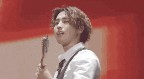a man in a white shirt and tie is holding a guitar