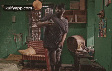 a man is dancing in a room with a couch and chair .