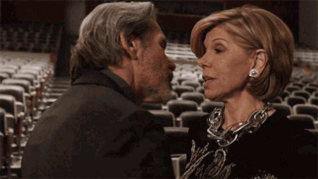 a man and a woman are looking at each other in a theater