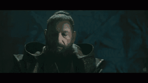 a man with a beard is wearing a hooded coat