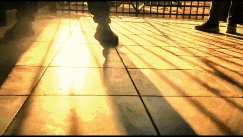 a person 's shadow is cast on a tile floor