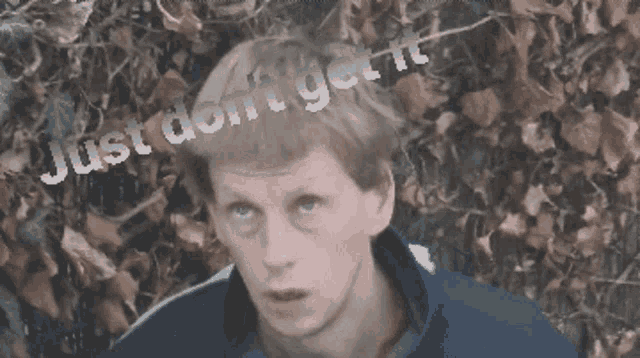 a man stands in front of a bush with the words just do n't get it on his head