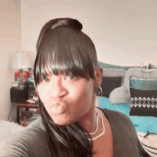 a woman with a ponytail and fringe is making a funny face