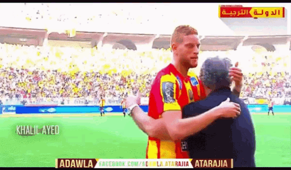 a man in a red and yellow jersey hugs another man