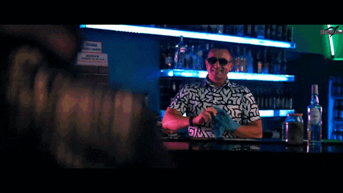 a man wearing sunglasses and a shirt is smiling