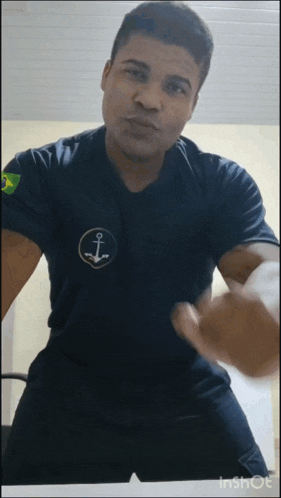 a man wearing a black shirt with an anchor on the front