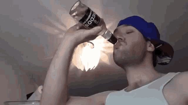 a man wearing a blue hat is drinking from a bottle that says ' sds ' on it