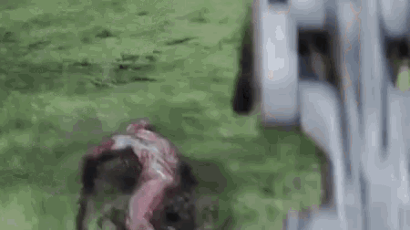 a zombie is crawling on the ground in front of a machine .