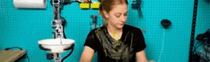a woman in a black shirt is standing in front of a machine .