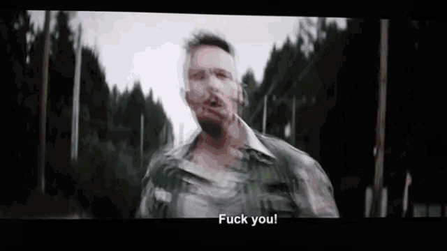 a blurry picture of a man saying fuck you in front of a forest