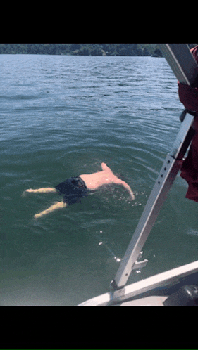 a man is swimming in a body of water with his feet in the water