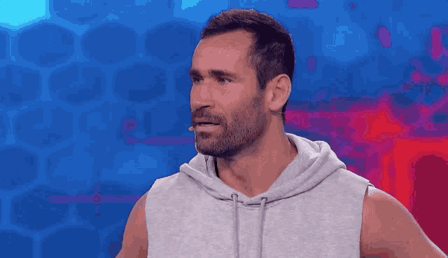 a man with a beard wearing a gray hoodie