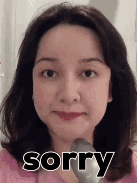 a woman is making a funny face with the word sorry written on her face