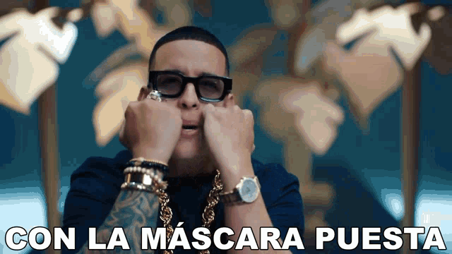 a man wearing glasses and a watch with the words con la mascara puesta written below him