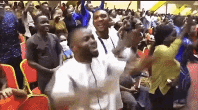 a man is dancing in front of a crowd of people in a room .