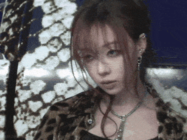 a girl with red hair is wearing a leopard print jacket