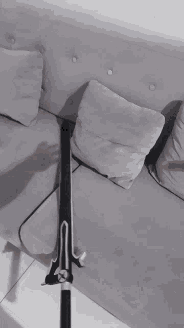 a sword is sitting on a white couch with pillows
