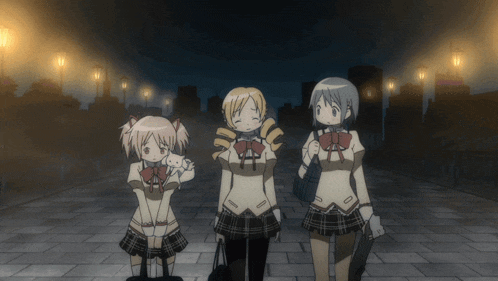 three anime girls are standing on a brick walkway at night