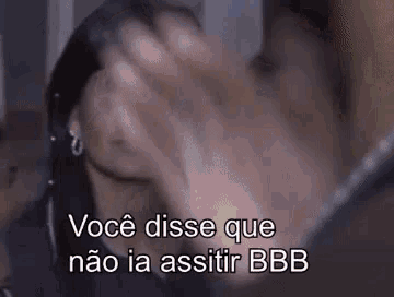 a person is covering their face with their hands and the words `` você disse que não ia assistir bbb '' are visible .