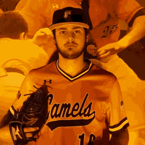 a man wearing a camels jersey holds a glove