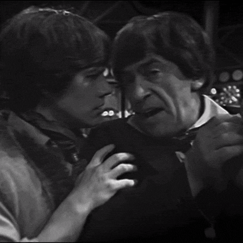 a black and white photo of a man holding another man 's hand