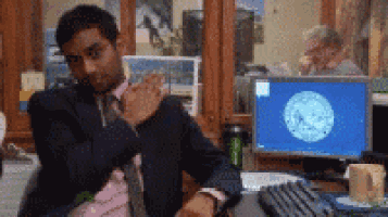 a man in a suit is sitting at a desk in front of a computer