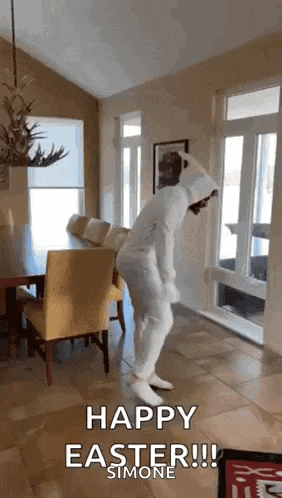 a person in a bunny costume is dancing in a living room with the words `` happy easter ! ''