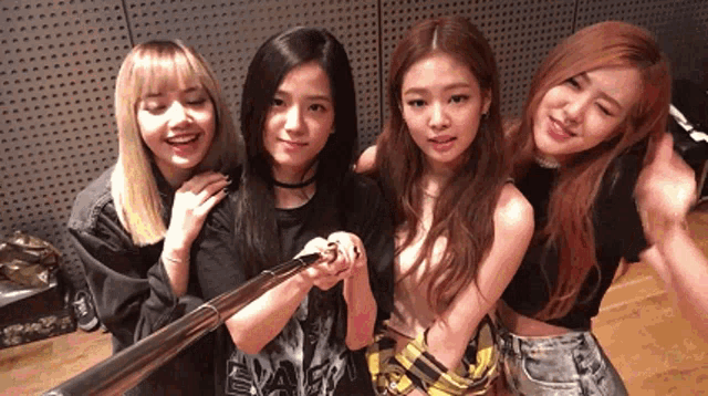 a group of young women are posing for a picture with a selfie stick