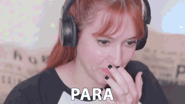 a woman wearing headphones is covering her nose with her hand and the word para is on the bottom right