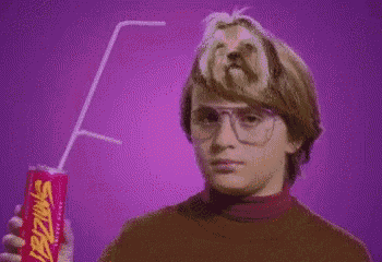 a boy with glasses is holding a can of swish soda
