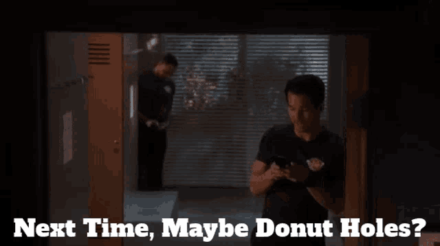 a man in a black shirt is looking at his phone with the words next time maybe donut holes below him