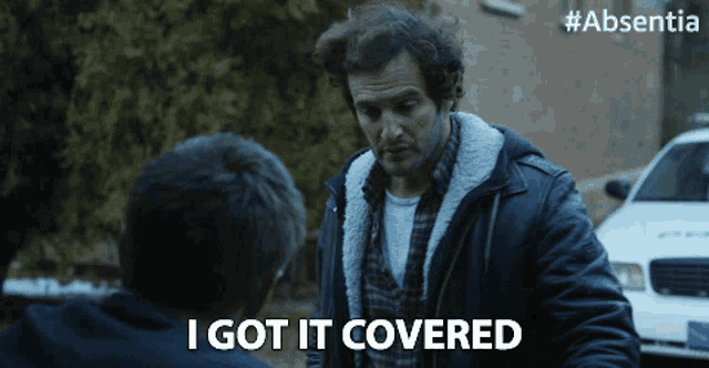 a man says i got it covered in front of a white car