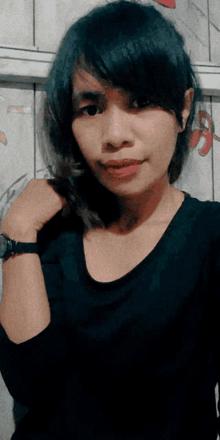 a woman wearing a black shirt and a watch poses for a picture