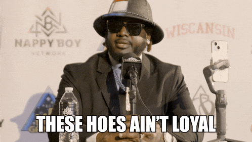 a man speaking into a microphone with the words these hoes ain t loyal