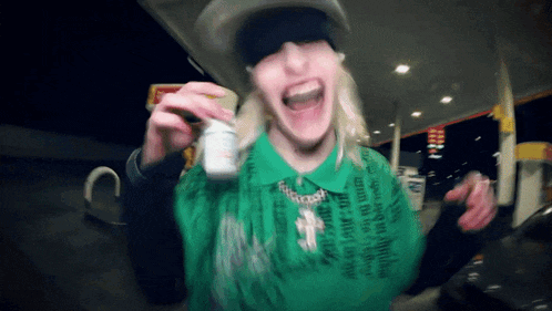 a woman in a green shirt is holding a bottle of pills