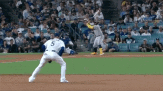 a baseball player with the number 5 on his jersey is getting ready to throw the ball .