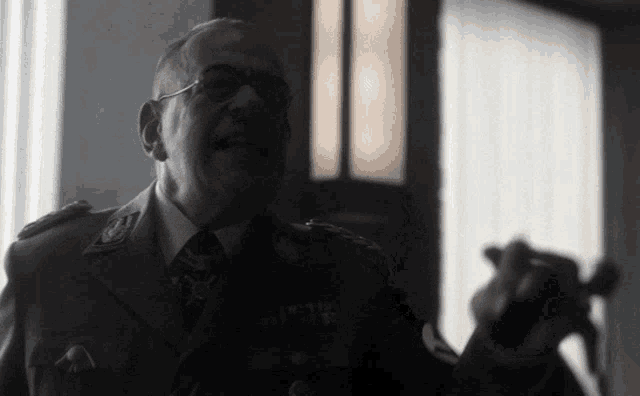 a man in a military uniform is holding a sword